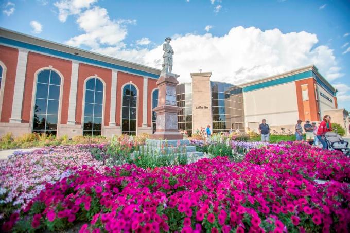 Purple Flowers Surrounding a Central Stone Statue Beside the Centre